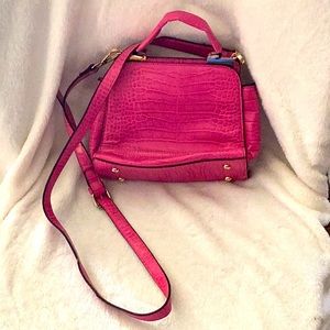 This is a pink cluch with snake paturn and gold spots.